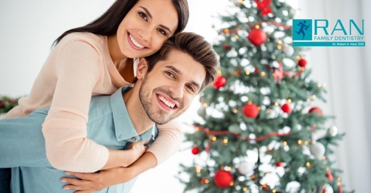 happy couple smiling bright christmas tree